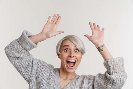 Delighted beautiful silver girl posing with hands up isolated over white backgroundの写真素材