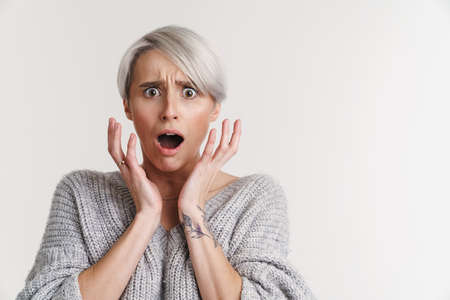 Scared beautiful silver girl expressing surprise at camera isolated over white backgroundの写真素材