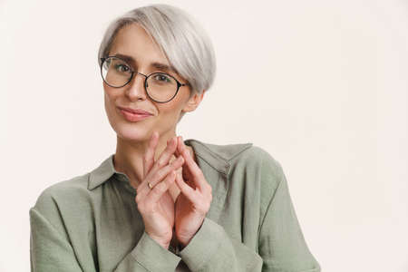 Young pleased woman in eyeglasses posing and looking at camera isolated over white background