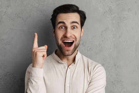 Excited man pointing a great idea isolated over gray background