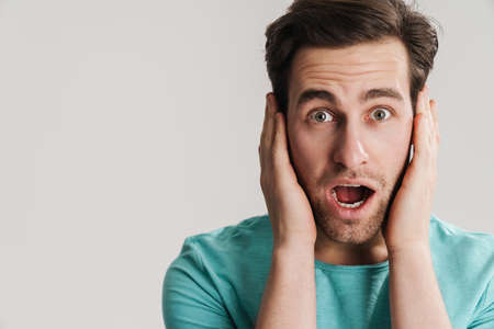 Close up shot of shocked stunned male stares at camera with jaw dropped outの写真素材