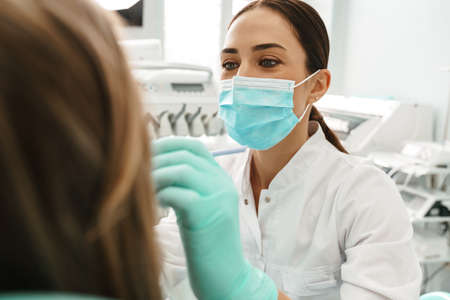 European mid dentist woman in face mask working in dental clinicの写真素材