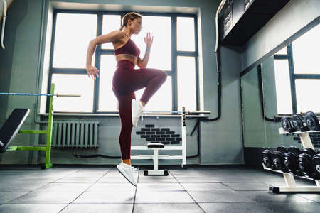 Caucasian athletic sportswoman doing exercise while working out in gym