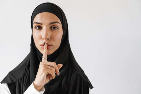 Young muslim woman in hijab unrolling fitness mat indoorsの写真素材