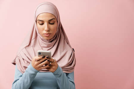 Young muslim woman in hijab unrolling fitness mat indoorsの写真素材