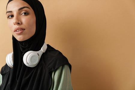 Young muslim sportswoman in hijab doing exercise while working out indoorsの写真素材