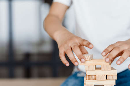 Cropped photo of boy playing with wooden planks at homeの写真素材