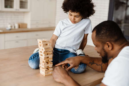 Black father and son playing with planks together at homeの写真素材