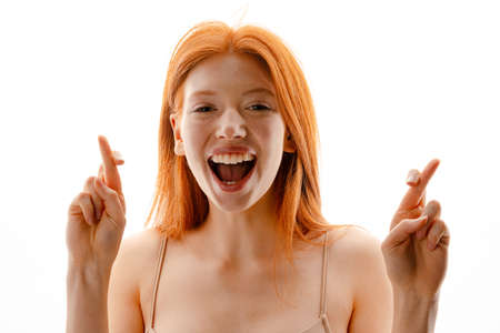 Portrait of a happy young redhead woman with healthy freckled skin posing isolated over whiteの写真素材
