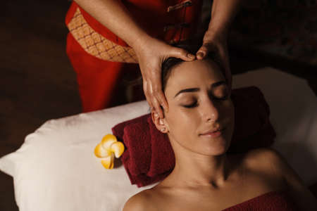 White relaxed mid woman lying at massage session in spa indoorsの写真素材