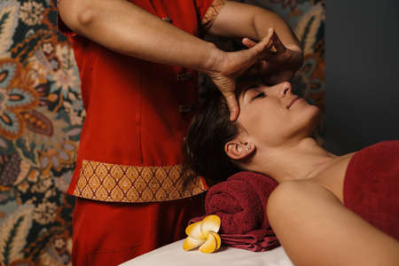 Brunette woman getting a back massage in a spa salonの写真素材