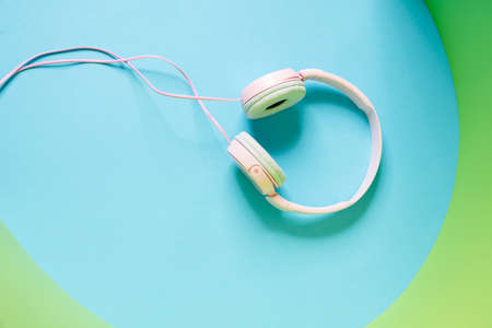 Overhead view of a pink wired headphones lying in the blue studio