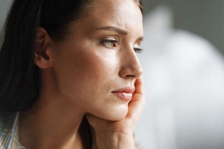 Young brunette woman posing and looking aside indoorsの写真素材