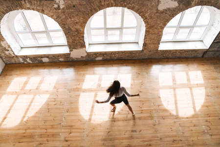 Young brunette white woman dancing contemporary in the studio top viewの写真素材