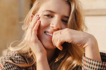 Close up of a smiling young blonde casual woman on a street, posingの写真素材