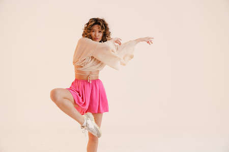 Young hispanic woman wearing skirt dancing on camera isolated over white background