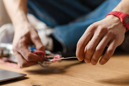 Young white man working with sewing machine indoorsの写真素材