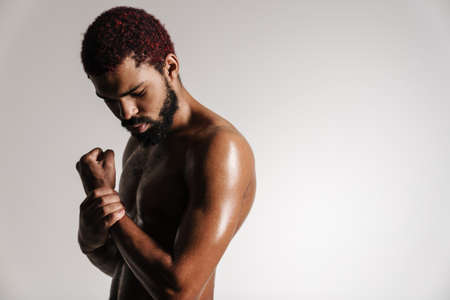 Black shirtless bearded man posing and looking downward isolated over white backgroundの写真素材