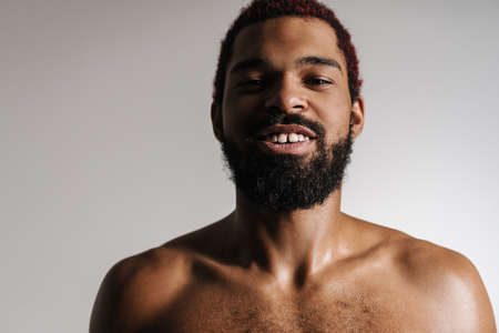 Black shirtless bearded man smiling and looking at camera isolated over white backgroundの写真素材