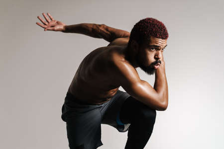 Black shirtless sportsman running while working out isolated over white backgroundの写真素材