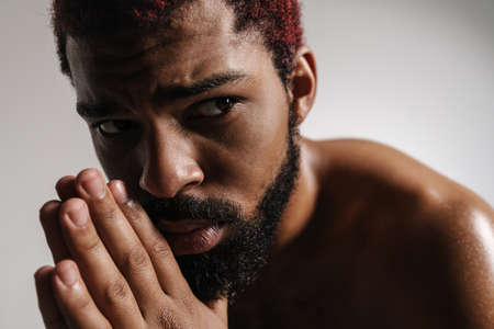 Black shirtless bearded man posing and looking aside isolated over white backgroundの写真素材
