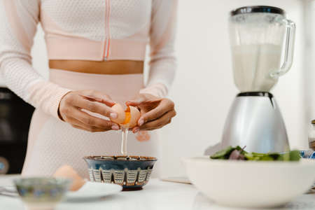 Cropped photo of black woman cooking in kitchen at homeの写真素材