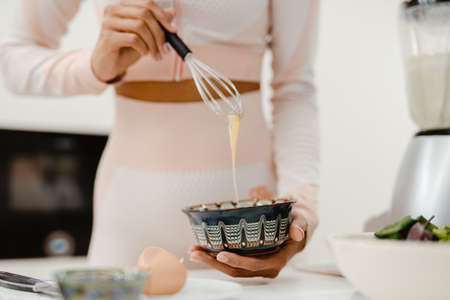Cropped photo of black woman cooking in kitchen at homeの写真素材