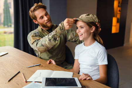 Masculine happy military man making fun with her daughter at homeの写真素材