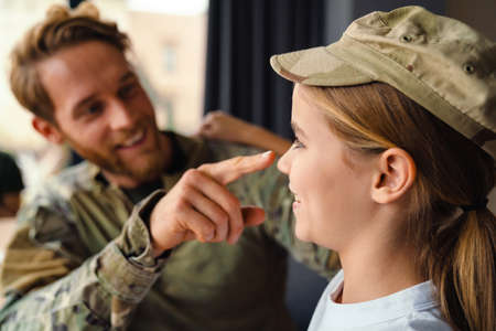 Masculine happy military man making fun with her daughter at homeの写真素材