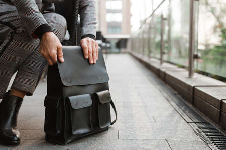 White senior woman holding her bag while sitting in cafe outdoorsの写真素材