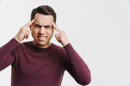 Young brunette man with headache rubbing his temples isolated over white background