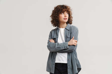 Young ginger white woman posing with arms crossed isolated over white background