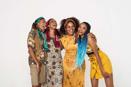 Young black four women wearing dress hugging and laughing isolated over white background
