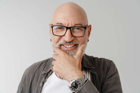 Bald european man in eyeglasses laughing and looking at camera isolated over white background