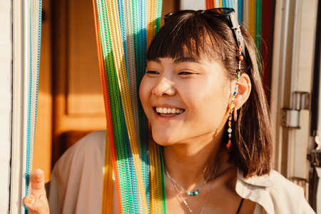Asian young woman with piercing making fun in trailer door outdoors