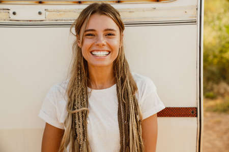 White young woman with pigtails smiling while leaning on trailer outdoorsの写真素材