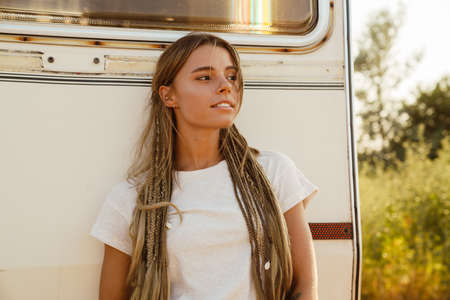 White young woman with pigtails looking aside while leaning on trailer outdoorsの写真素材
