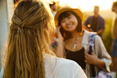 Multiracial women smiling and talking during picnic with their friends outdoorsの写真素材
