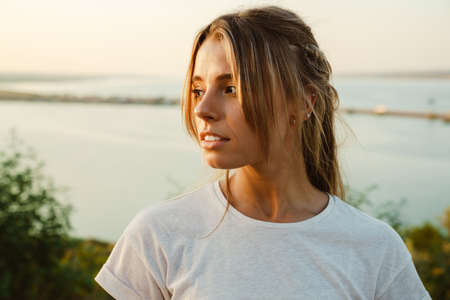 White young woman with pigtails posing and looking aside outdoors