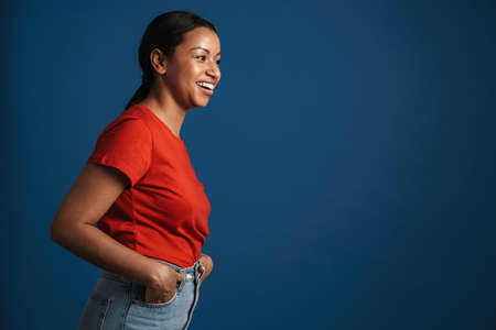 Young african american woman wearing t-shirt smiling at camera isolated over blue background