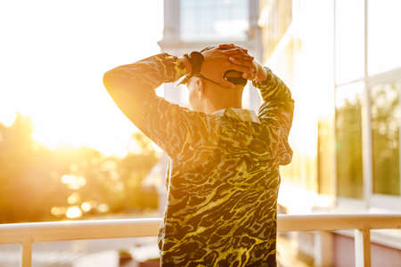 Young sportsman doing exercise while working out by building outdoors
