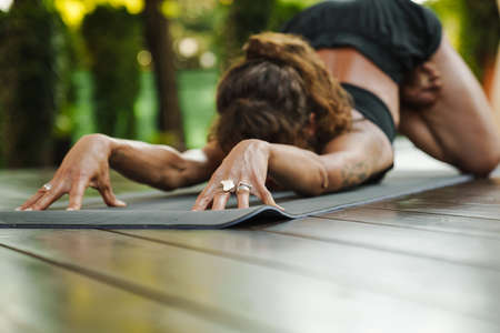 Young white woman doing exercise during yoga practice outdoors
