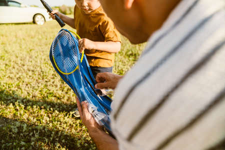 Young white father and son playing badminton together outdoorsの写真素材