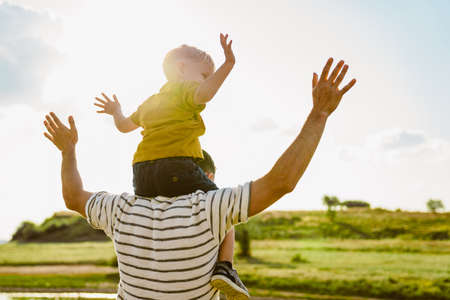 Young white father and son gesturing and playing together outdoorsの写真素材