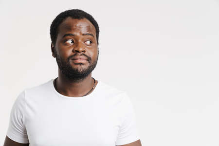 Black bristle man looking aside while posing at camera isolated over white background