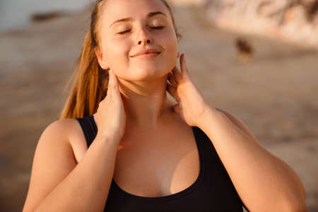 Young ginger woman doing exercise during yoga practice outdoorsの写真素材