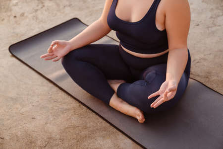 European young woman meditating during yoga practice outdoorsの写真素材