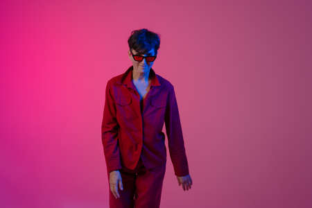 Mature european woman wearing sunglasses posing on camera isolated over pink background