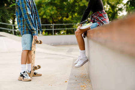 White teenagers talking while spending time at skate park outdoors