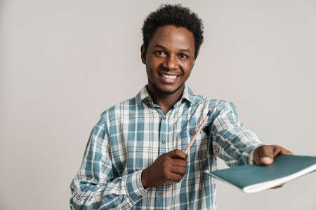 Black unshaven man in plaid shirt posing with exercise book isolated over white backgroundの写真素材